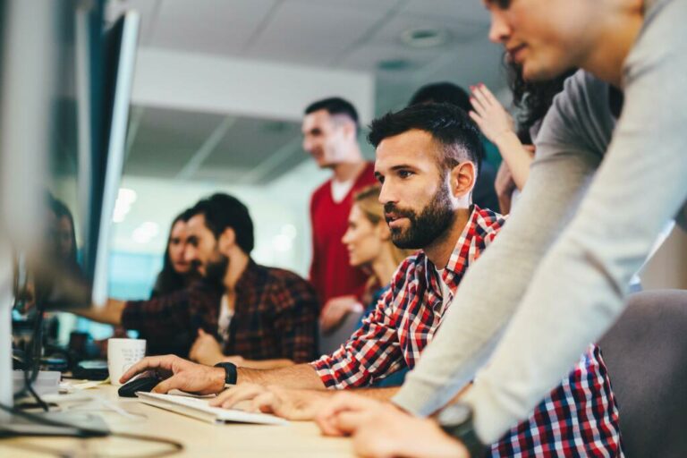 Group collaborating around a computer workstation.