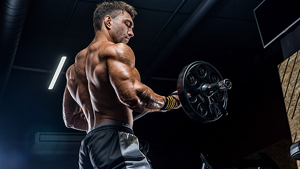 Bodybuilder lifting a barbell in gym.