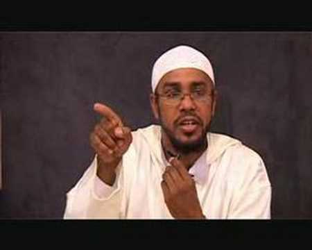 Man in white attire gesturing and speaking.