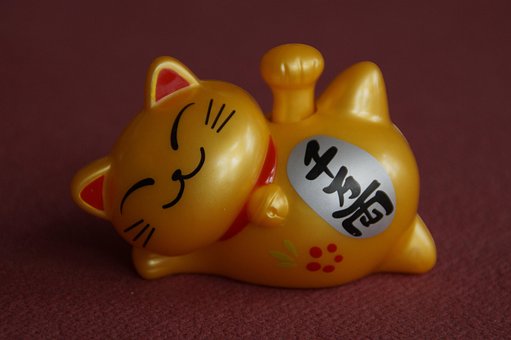 Smiling golden cat figurine resting happily.