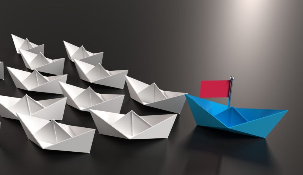 A row of paper boats with one boat in the middle.