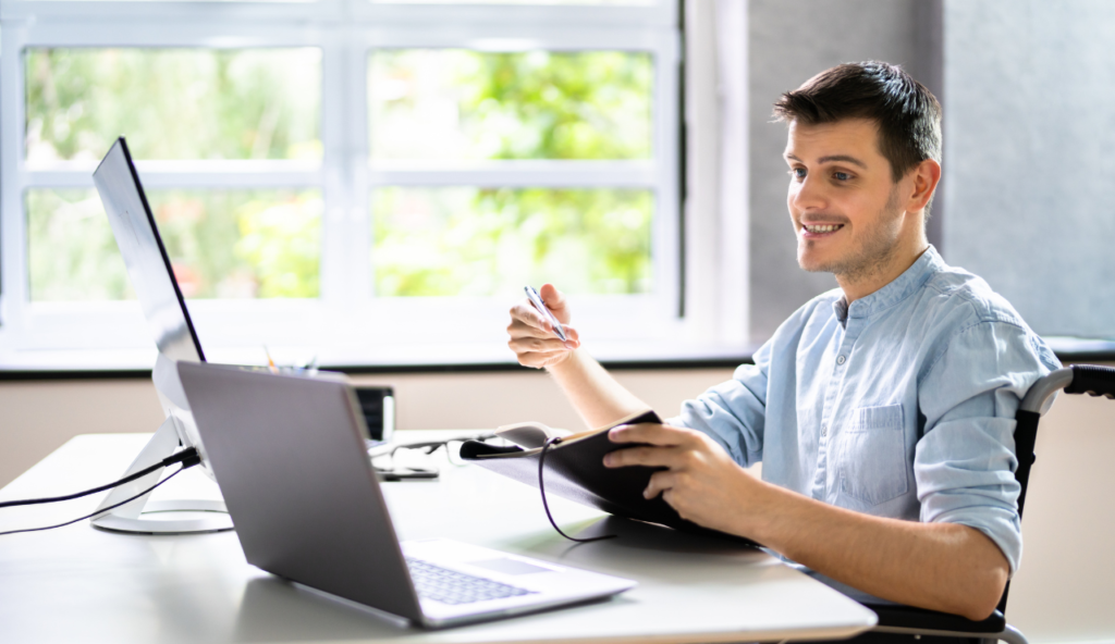 A man sitting at a table with a laptop.