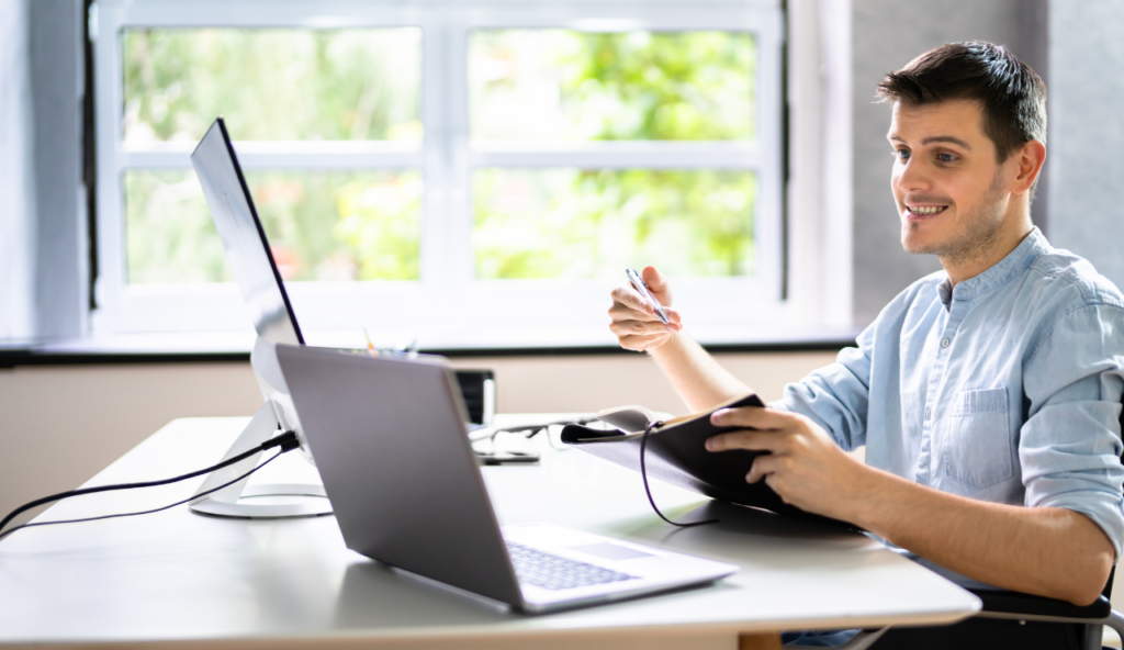 A person sitting at a table with a laptop.